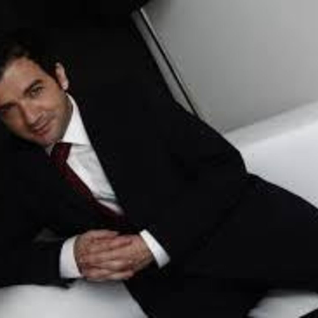 Homem de fato posa sorridente para a câmara