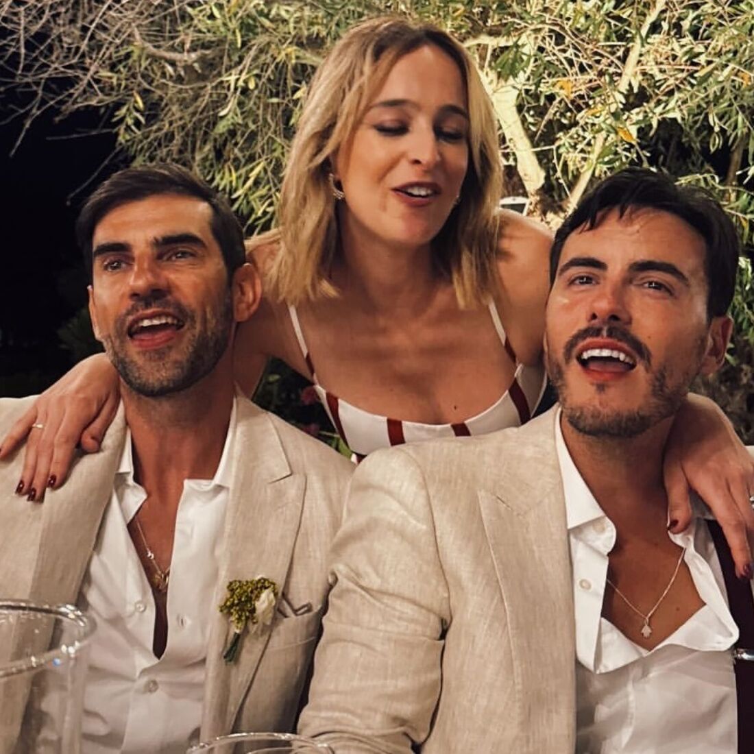 Três pessoas sorriem num evento