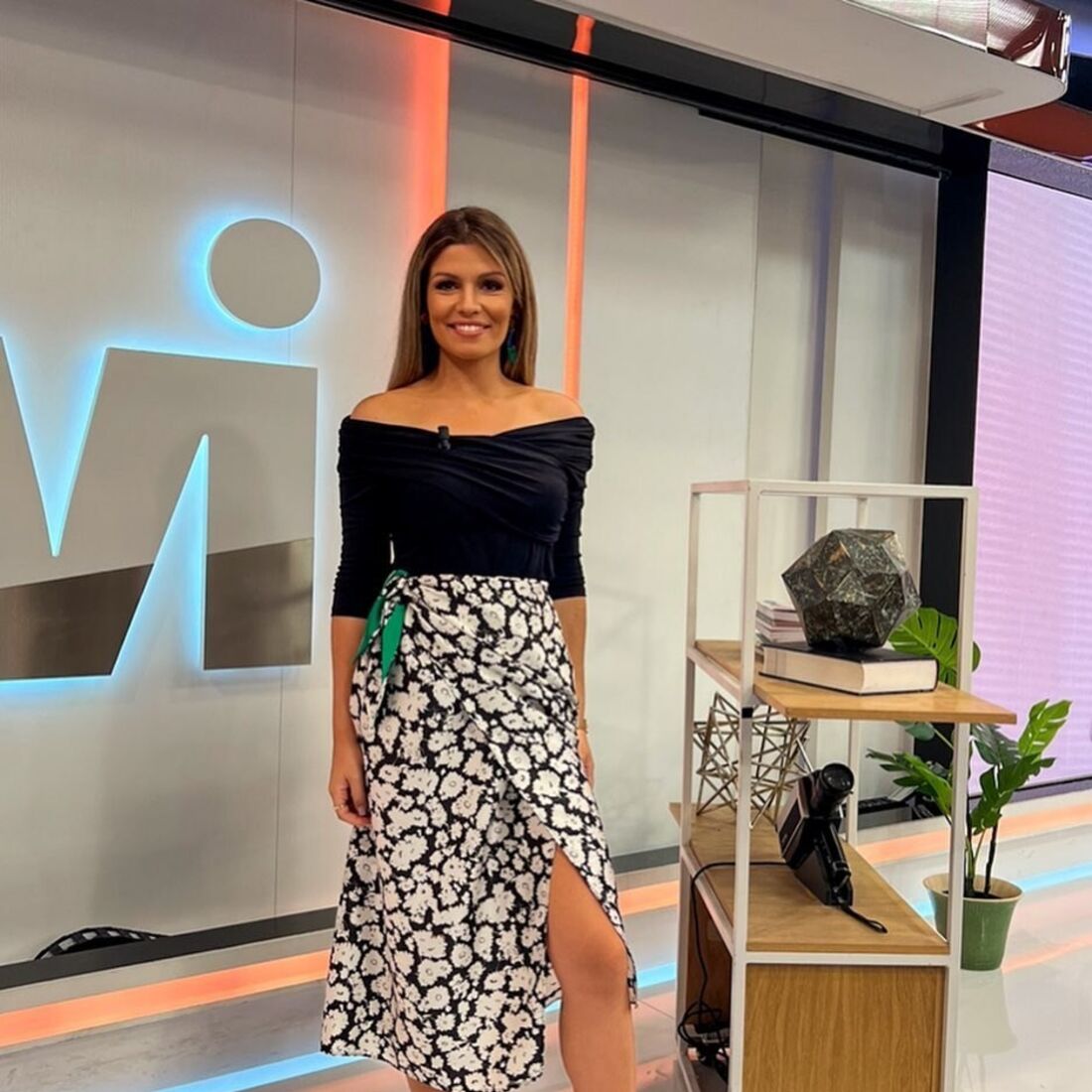A apresentadora surge elegante com um visual moderno no estúdio televisivo
