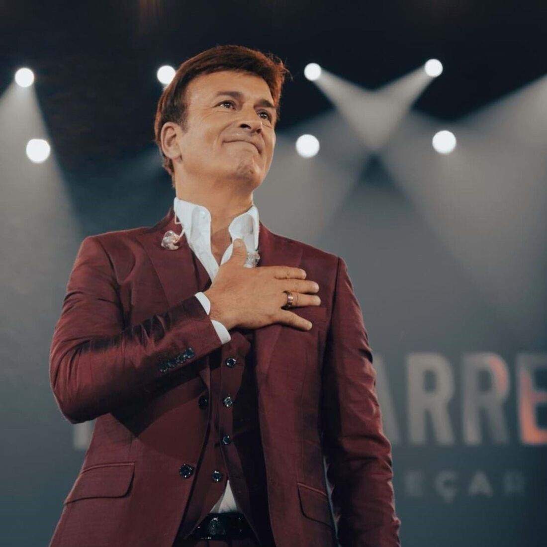 Tony Carreira atua perante uma plateia iluminada