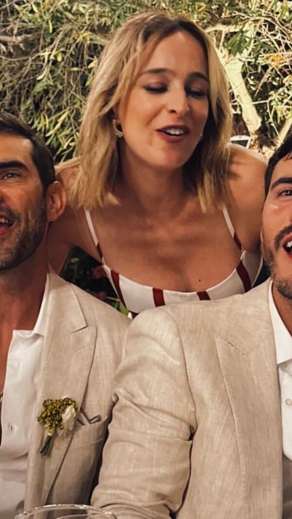 Três pessoas sorriem num evento