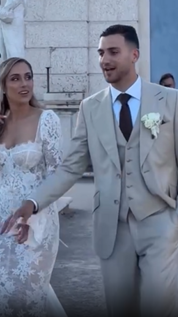 Casal celebra matrimónio em Portugal com trajes elegantes e cenário romântico.