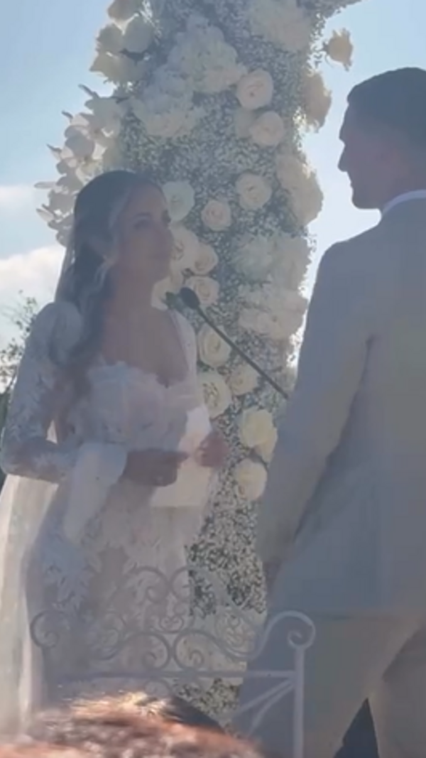 Casal celebra o matrimónio perante o altar decorado com flores brancas