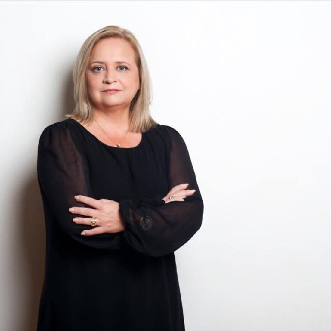 Retrato de mulher com braços cruzados e vestido preto