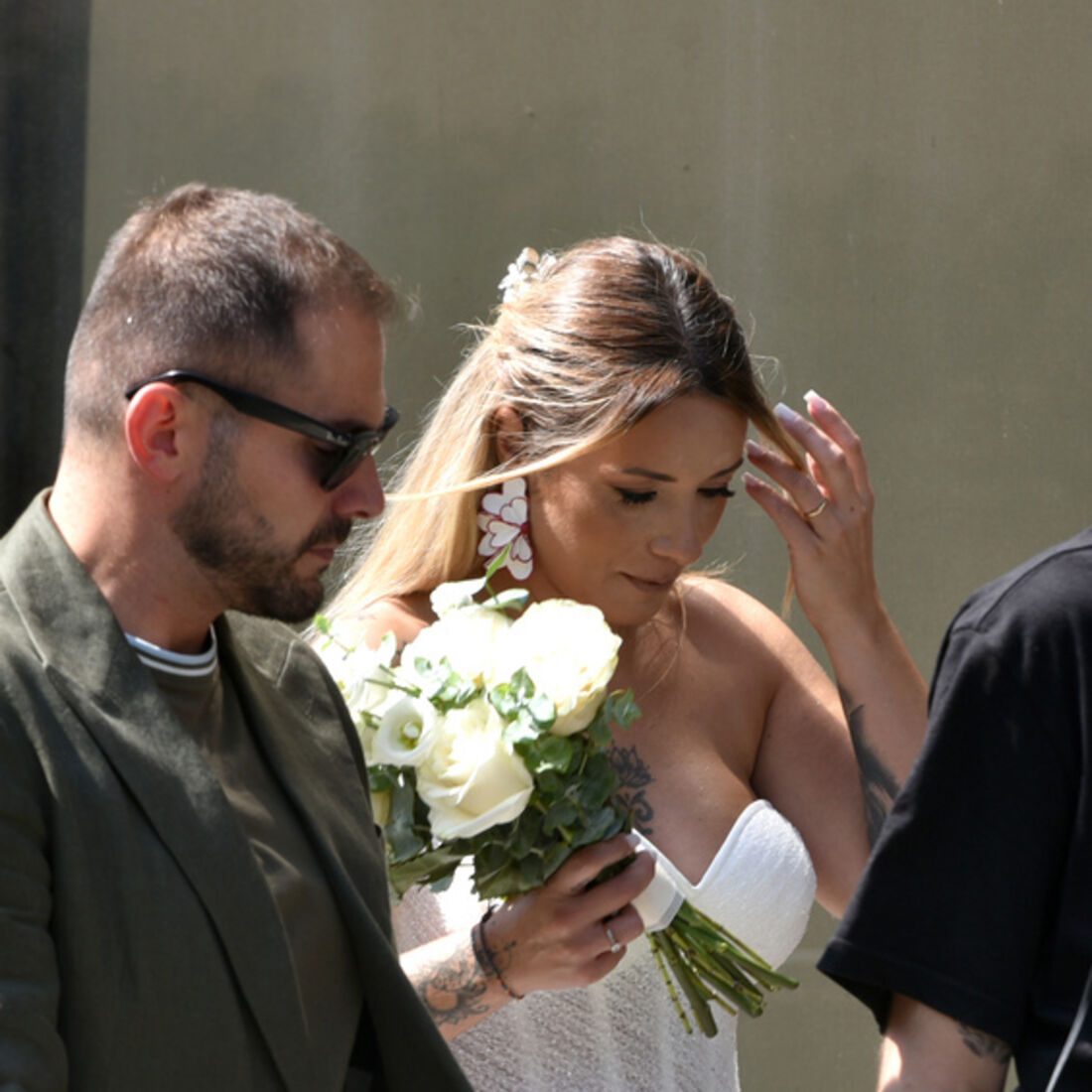 Noiva caminha com um bouquet de flores brancas no dia do casamento