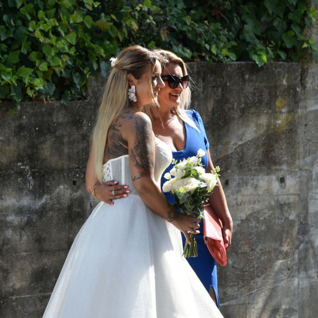 Noiva e convidada celebram enlace em dia de festa