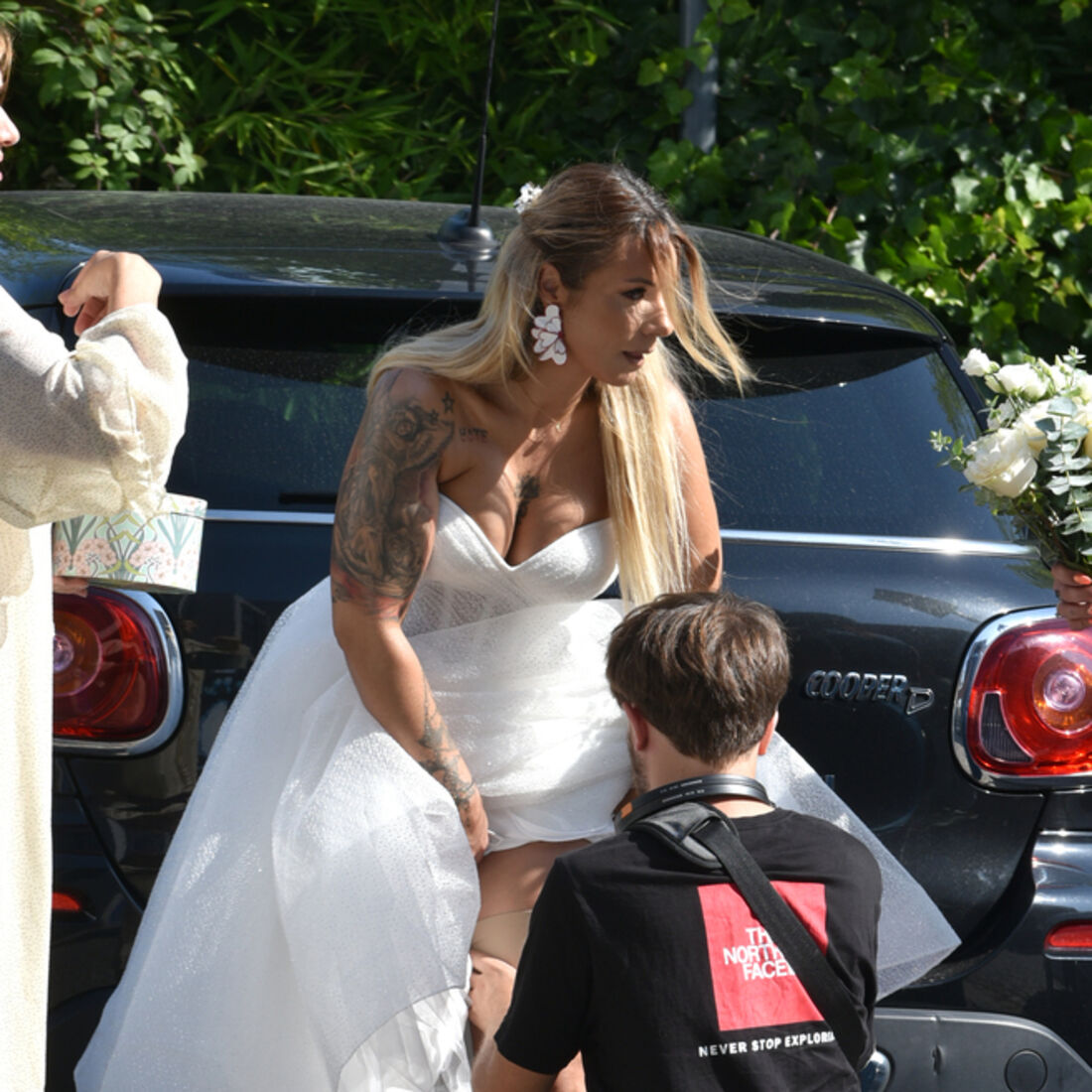 Noiva posa para fotógrafo junto a carro num dia de casamento