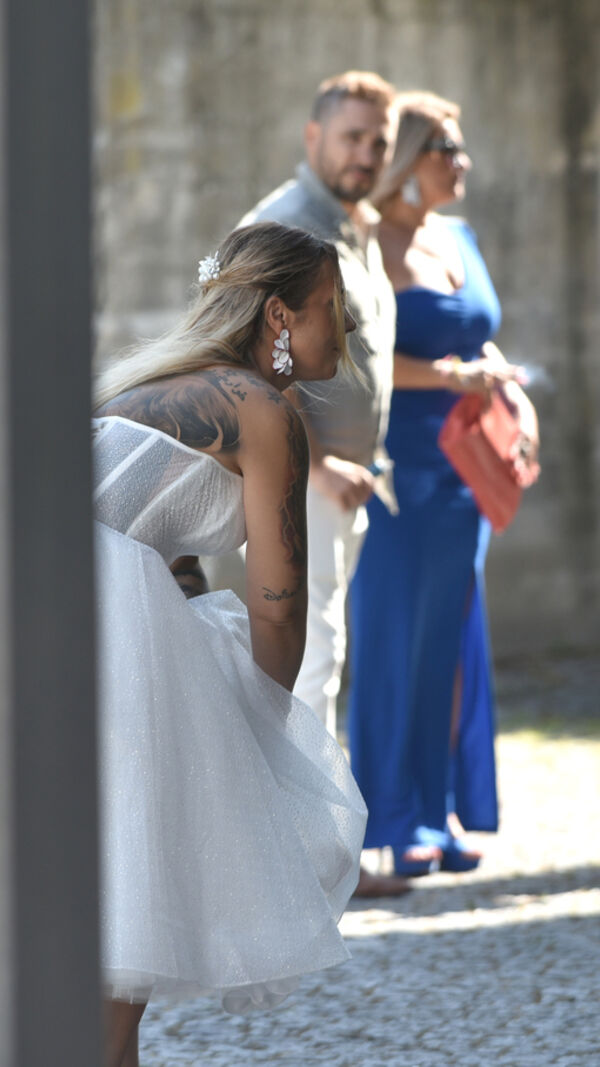 Noiva com vestido branco e convidados num evento