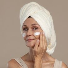 Mulher aplica creme facial da COSRX para firmeza e luminosidade da pele