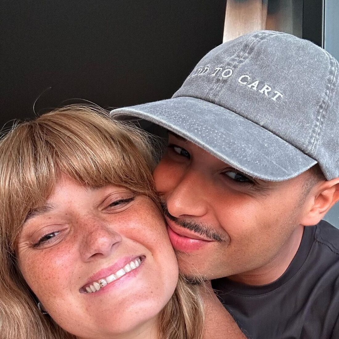 Um casal sorri para a câmara