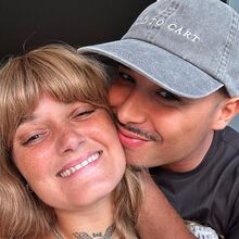 Um casal sorri para a câmara