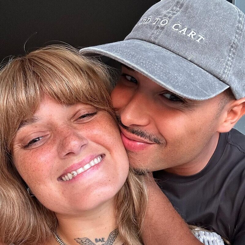 Um casal sorri para a câmara