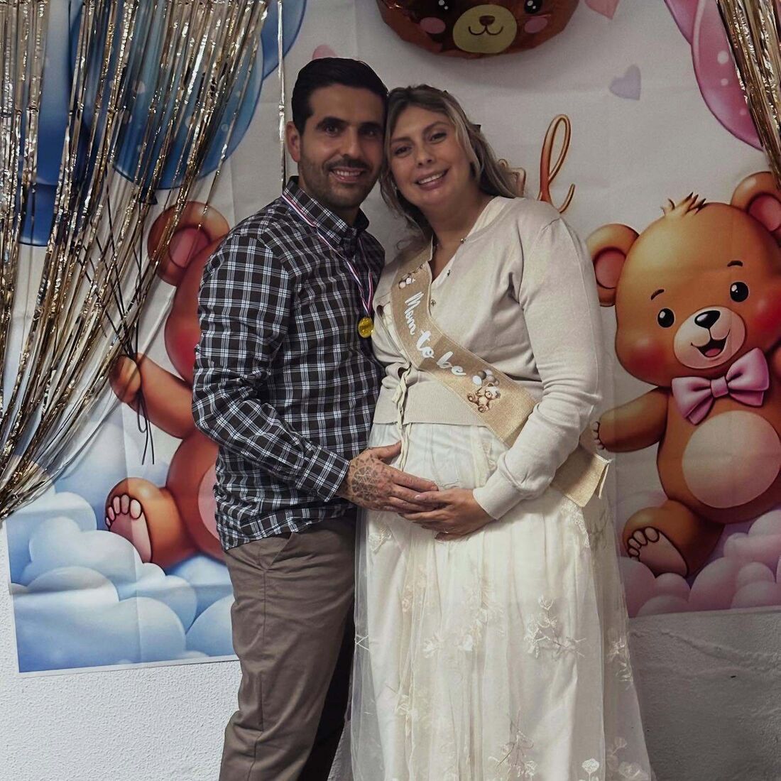 Casal sorri em celebração do futuro bebé