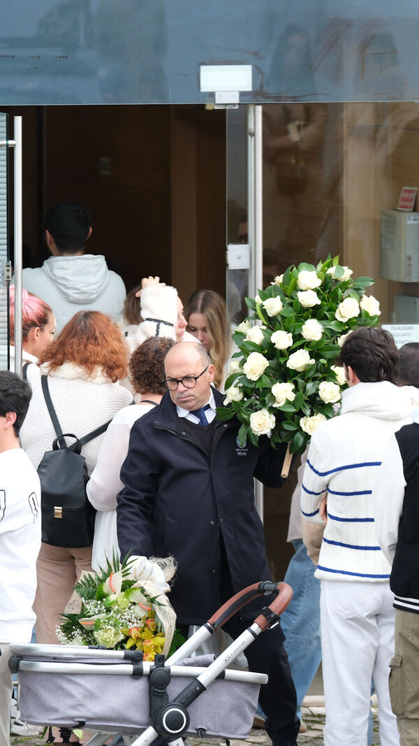 Pessoas reunidas perto de florista com flores.
