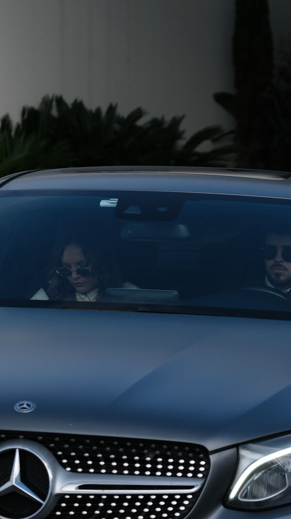 Casal visto num carro da Mercedes com outras pessoas por perto