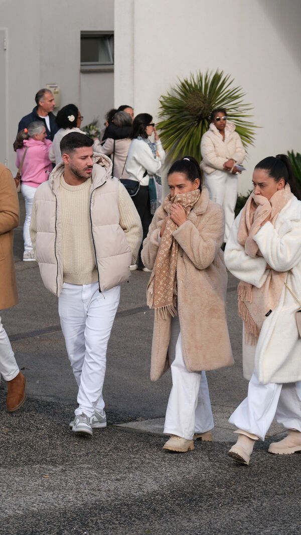 Pessoas caminham juntas com roupa de inverno bege e branca