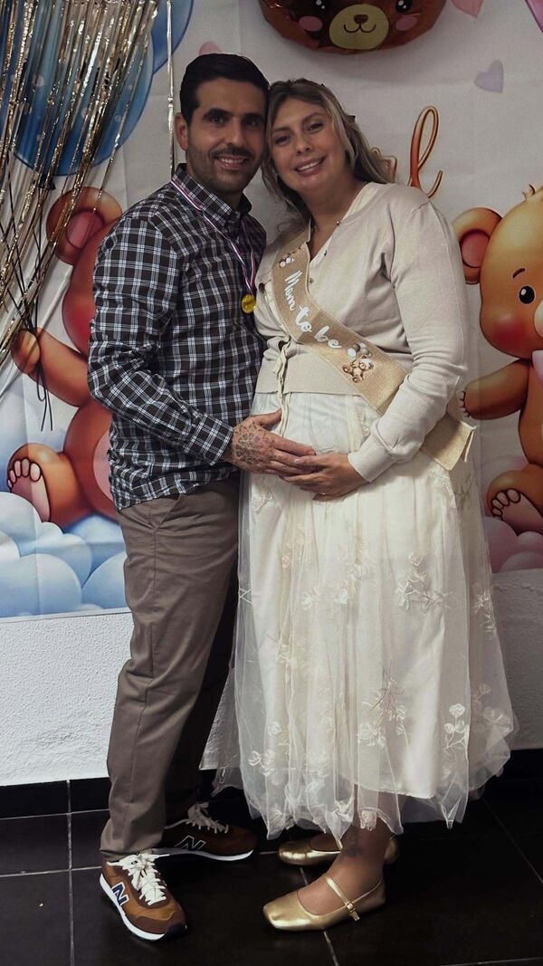 Casal sorri em celebração do futuro bebé
