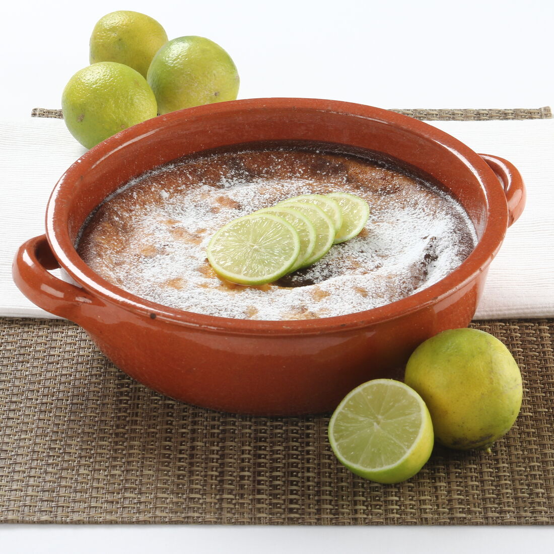 Tigelada de lima polvilhada com açúcar e decorada com citrinos fatiados