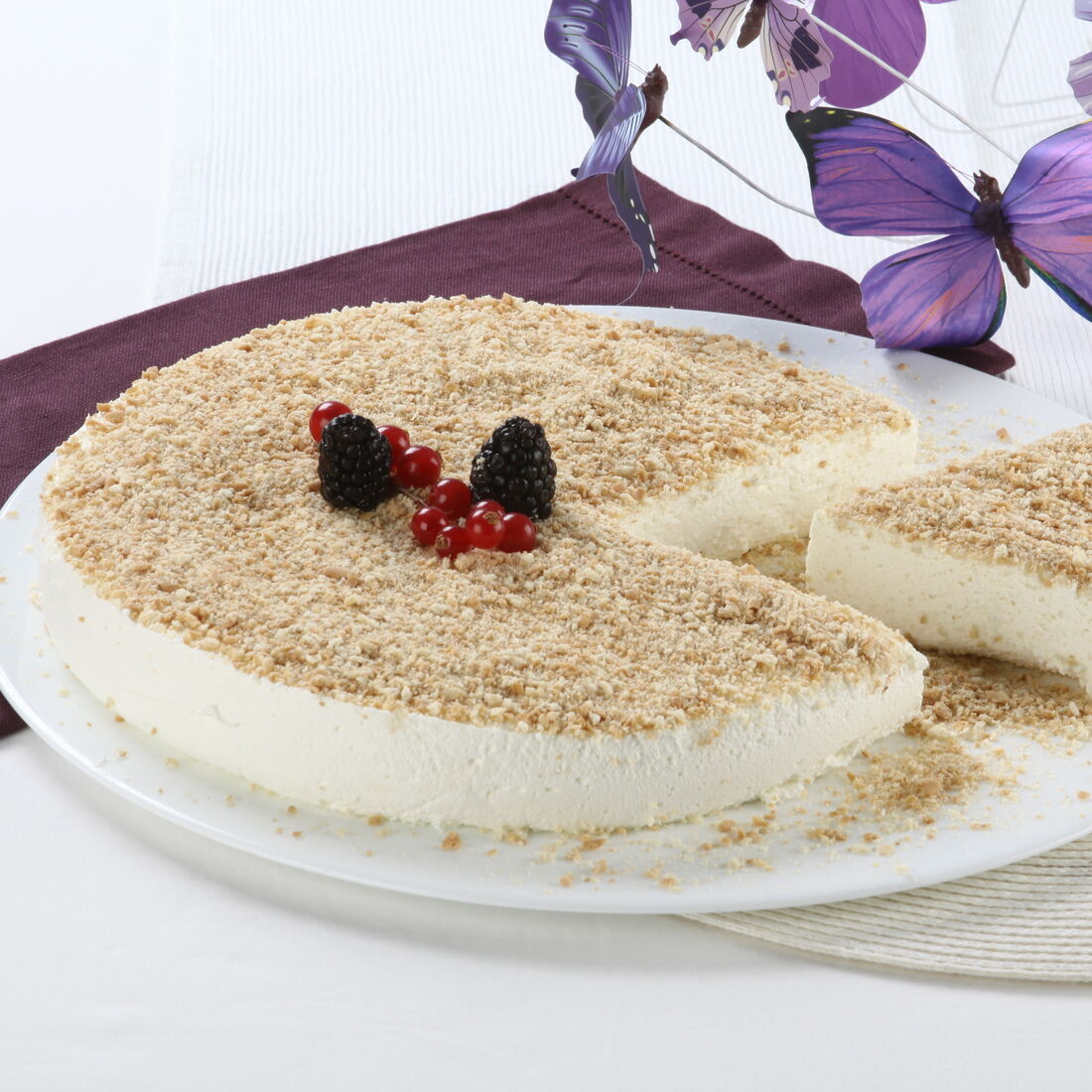 Tarte de natas com frutos vermelhos e borboletas decorativas