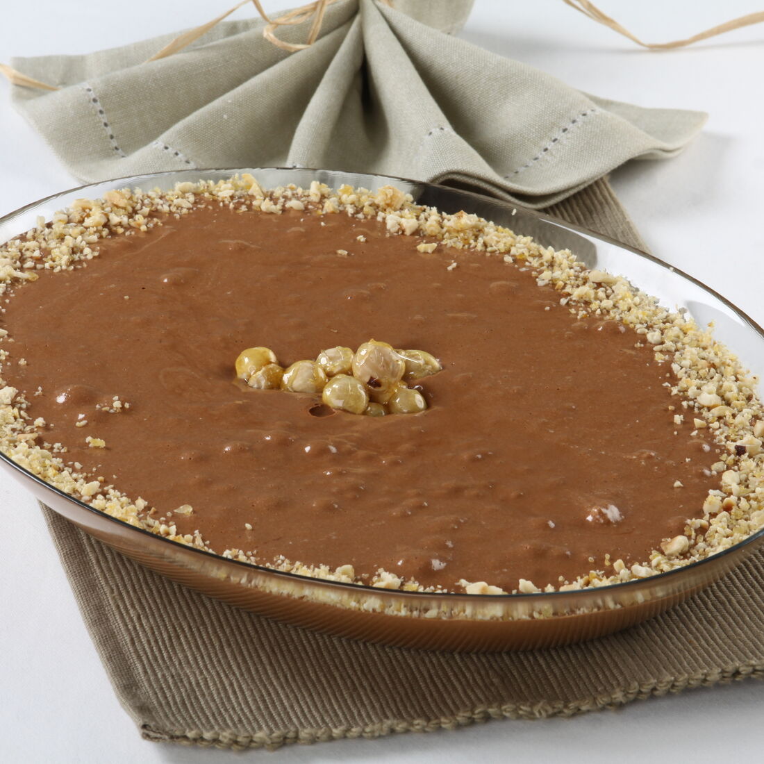 Musse de chocolate cremosa com avelãs, sobre um pano rústico