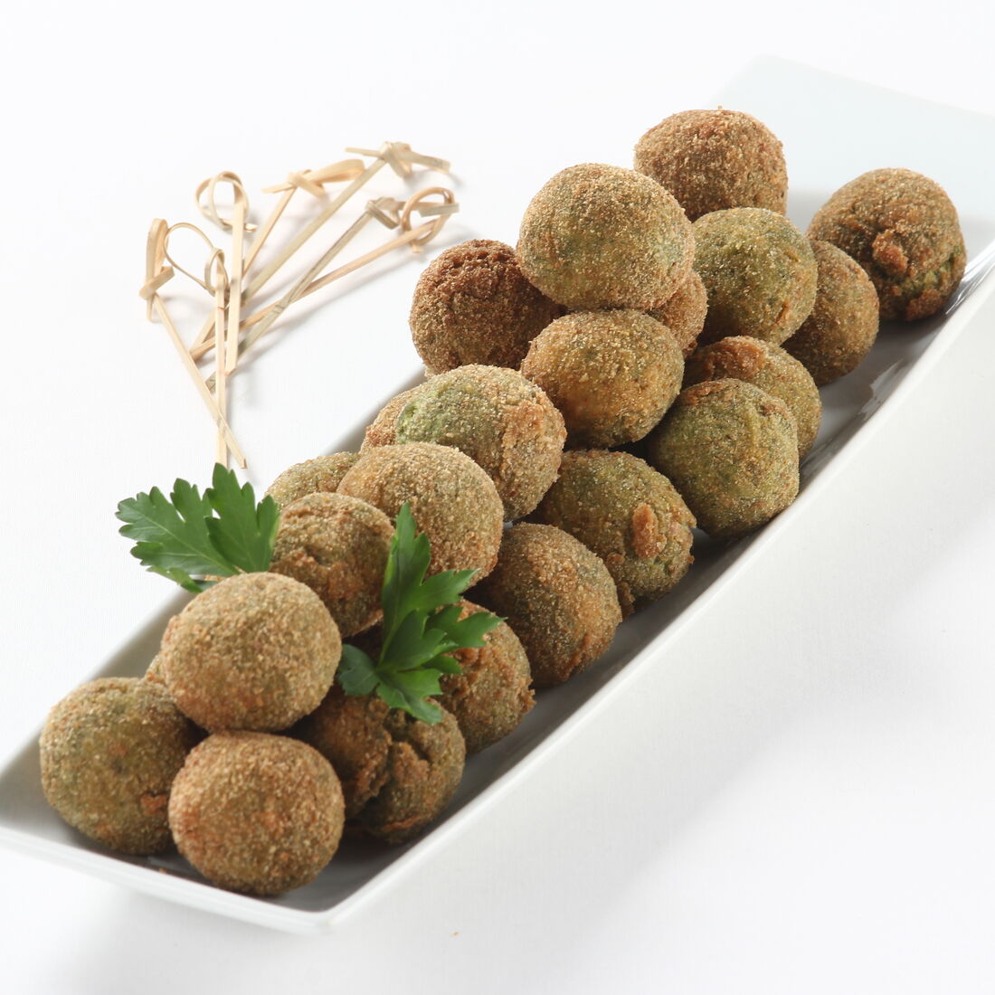 Croquetes de grão com espinafres servidos num prato branco