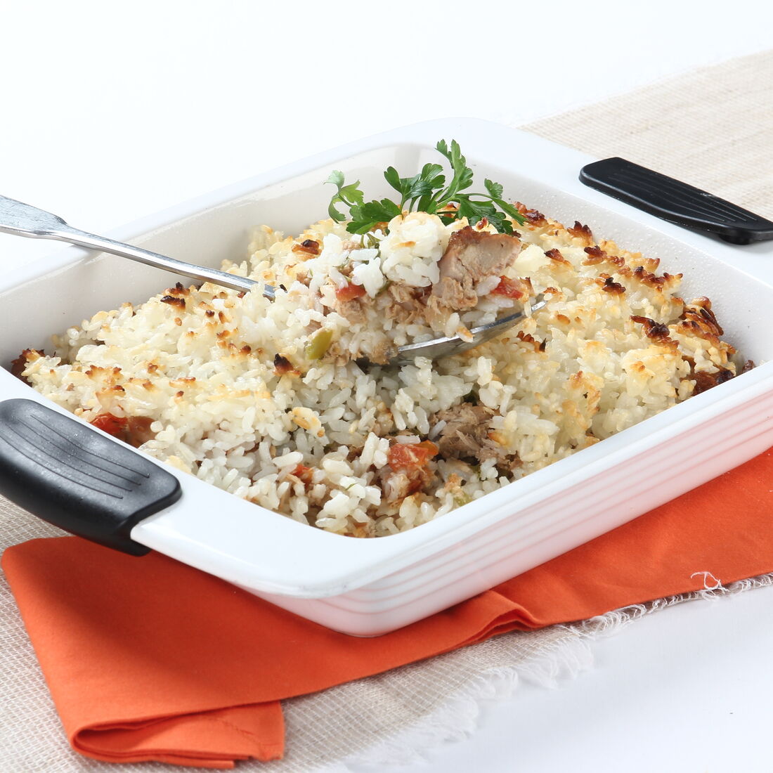 Arroz de atum cremoso, gratinado no forno, servido num pirex branco com pegas pretas