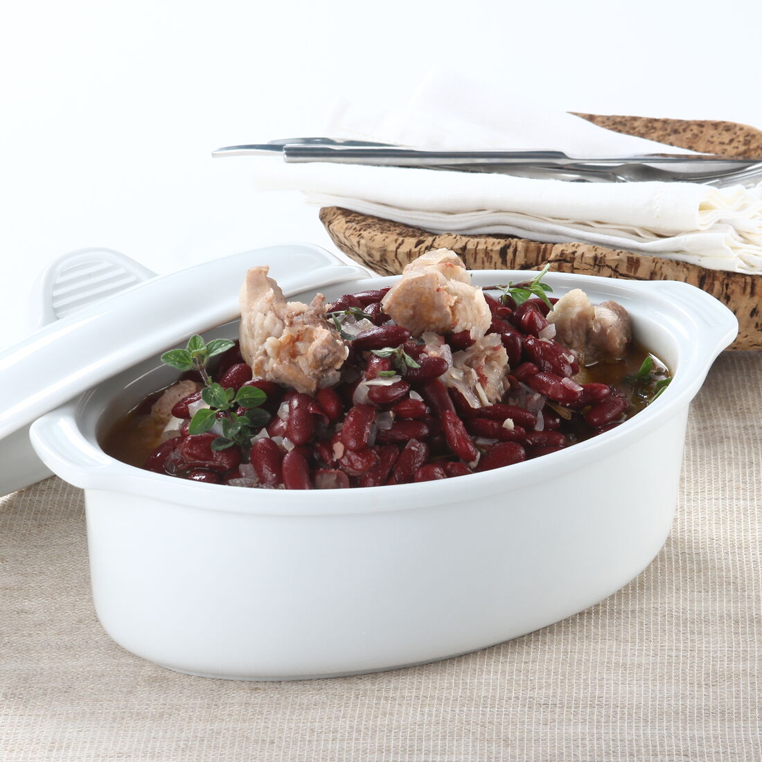 Feijoada de entrecosto num recipiente branco sobre um pano bege