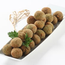 Croquetes de grão com espinafres servidos num prato branco