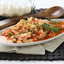 Risoto de frutos do mar com arroz, pimentos e coentros num prato branco