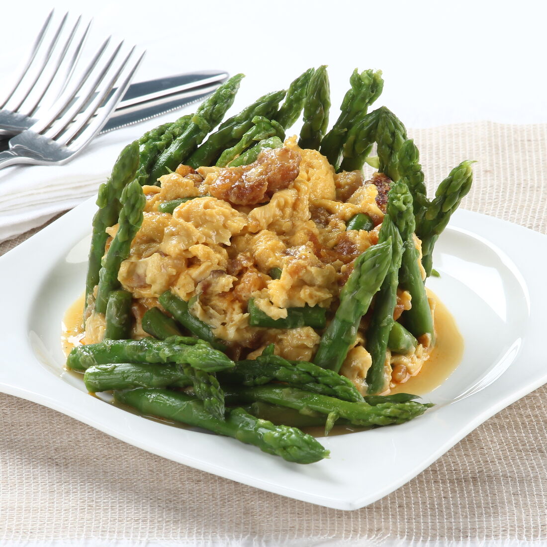 Ovos mexidos com farinheira e espargos num prato branco