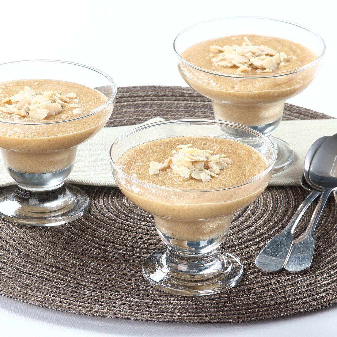 Sobremesa de mousse de cerveja servida em taças com amêndoas laminadas