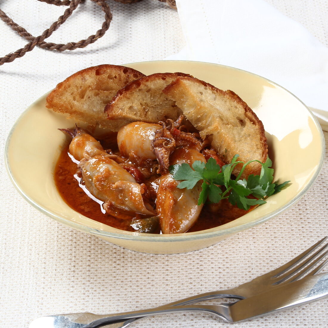 Lulas estufadas servidas com pão e salsa numa mesa elegante