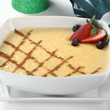 Taça de arroz-doce decorada com canela e frutos vermelhos