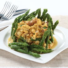 Ovos mexidos com farinheira e espargos num prato branco