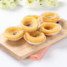 Queijadinhas de leite, dispostas com flores brancas, para uma mesa elegante