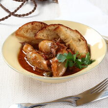 Lulas estufadas servidas com pão e salsa numa mesa elegante