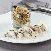 Strogonof de peru com arroz num copo e talheres