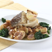 Bacalhau com batatas, cebola e grelos, prato típico português.
