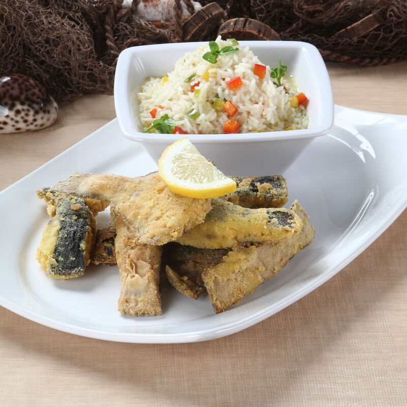 Solha frita com arroz de pimentos num ambiente rústico.
