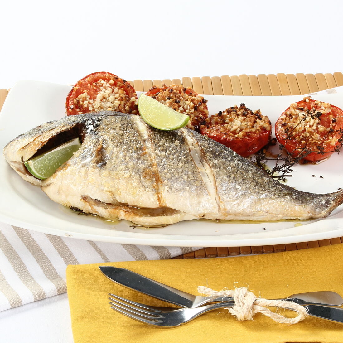 Dourada grelhada com limão e tomate recheado num prato