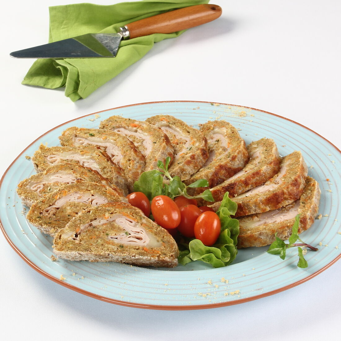 Torta de frango fatiada num prato com tomate e alface