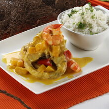 Caril de maruca com camarão e arroz, num cenário de rede de pesca