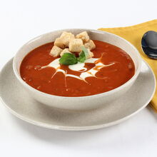 Sopa de tomate cremosa com cubos de pão e manjericão para um toque de frescura