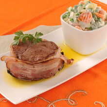 Tornedó com bacon e salada russa num prato
