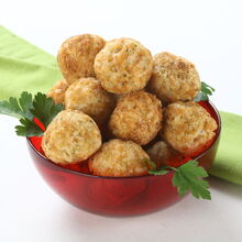 Bolinhas de salmão num recipiente vermelho, decoradas com salsa