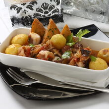 Prato de polvo estufado com batatas e torradas, pronto para servir
