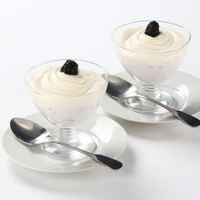 Mousse bicolor com natas e amoras pretas em taças de vidro
