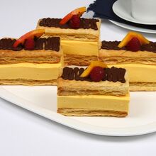 Fatias de massa folhada com creme de manga e decoração de chocolate e framboesa