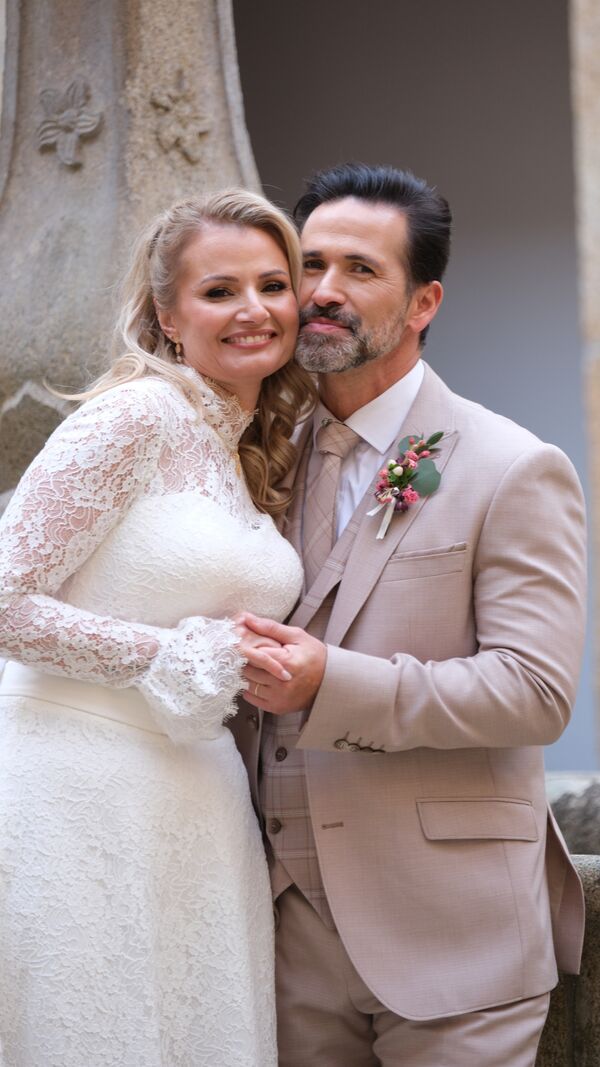 Casal sorridente posa no dia do casamento