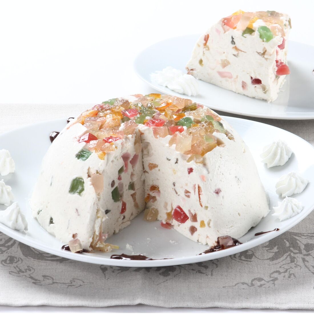 Delícia de fruta cristalizada em pratos com decoração de chocolate e chantilly